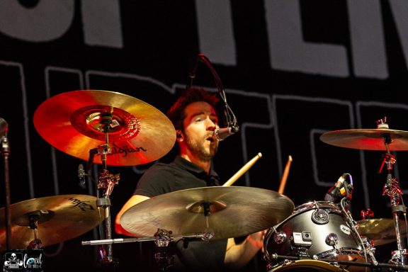 The Interrupters - l'Agora du Port de Québec Drummer performing on stage with cymbals and a microphone, focused on playing.