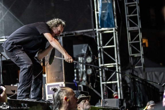A performer engages the crowd during a live outdoor concert event.