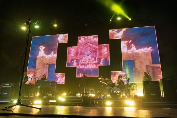 +LIVE+ - Centre Videotron Concert stage with vibrant screens displaying colorful visuals and bright lights.