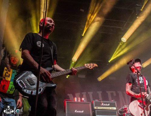 Band performing on stage with dramatic lighting and instruments.