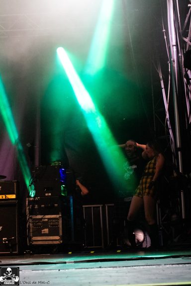 A performer dances on stage with green and blue spotlights illuminating the background.
