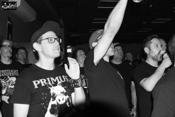 Straightline - L'Anti-Bar & Spectacles A crowd of concertgoers enjoying a live performance, some with hands raised.