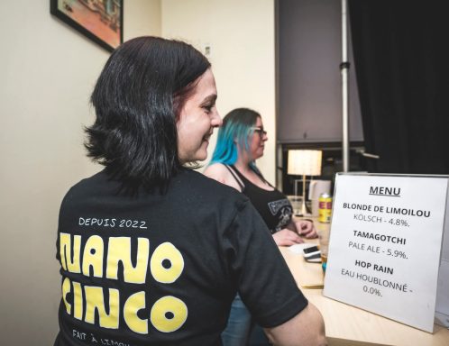 Pépé et sa guitare - Radiothon CKRL 89,1 Two women at a table, one with blue hair, promoting an event with a sign listing details.