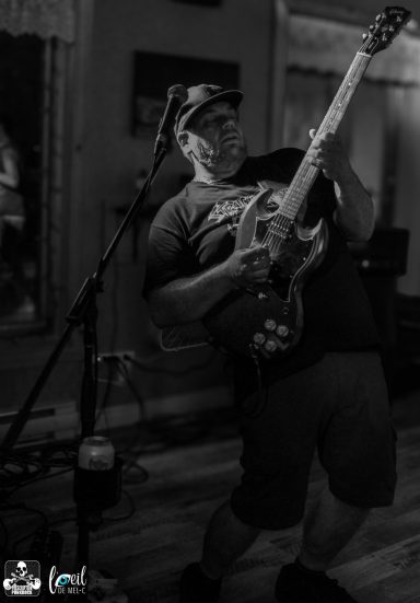 A musician passionately playing an electric guitar on stage.
