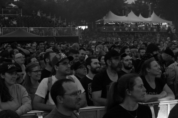 Crowd of people at a concert, focused and engaged with the performance.