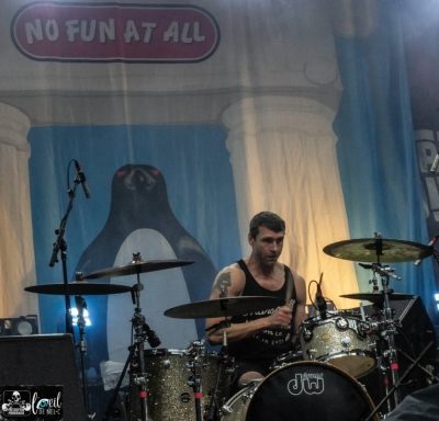 No Fun At All - Red Bridge Fest 2026 Drummer performing on stage with a colorful backdrop featuring a penguin.
