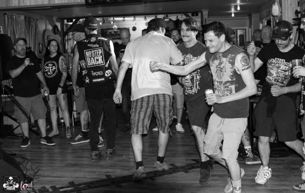 Crowd at a concert dancing and enjoying the performance in a lively venue.