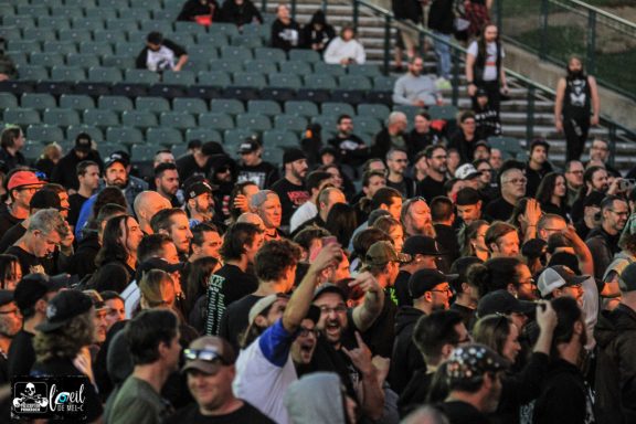 A crowd of enthusiastic fans enjoying a live music event outdoors.