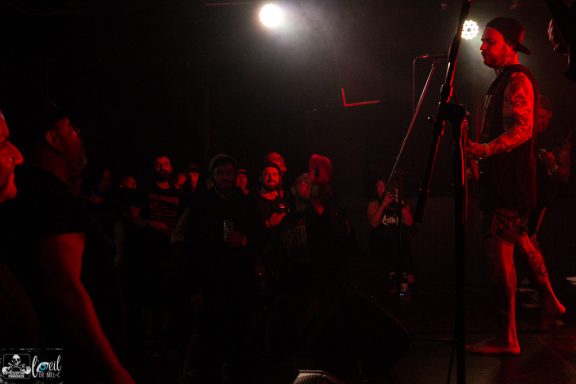 Straightline - L'Anti-Bar & Spectacles A musician performs on stage while an engaged crowd watches attentively.