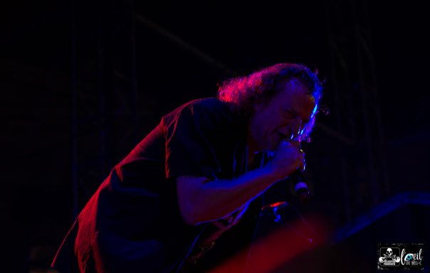 A singer performing passionately under dramatic stage lighting.