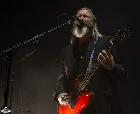 A musician passionately performing on stage with an electric guitar.