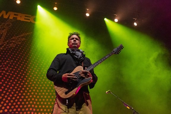 Big Wreck - Centre Videotron A musician performs on stage, holding an electric guitar with colorful lighting behind.