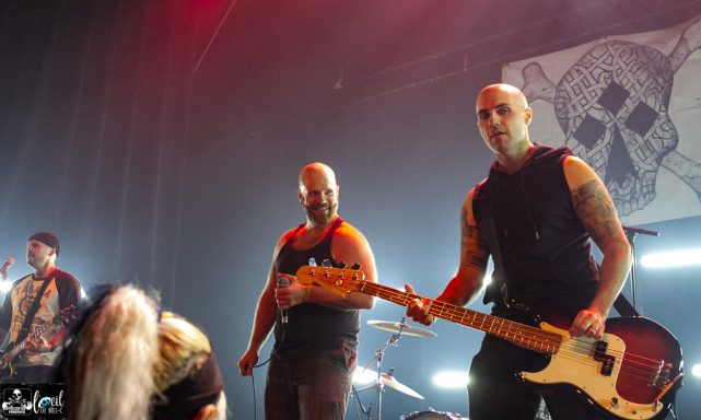 Musicians performing on stage with instruments and dramatic lighting.