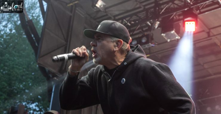 Pennywise - Red Bridge Fest 2026 A singer in a black hoodie performing on stage, microphone in hand, with dramatic lighting.