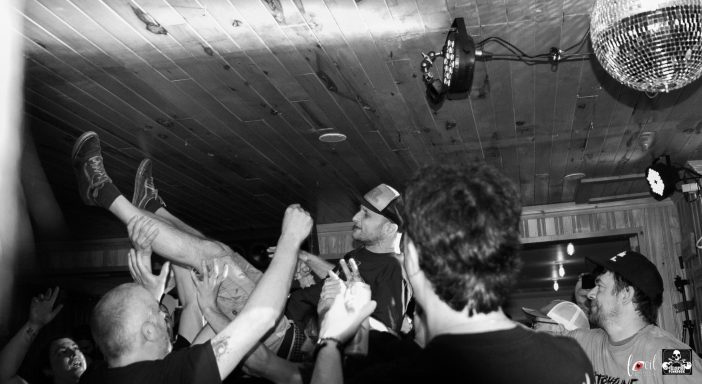 A crowd at a live music event, with a person crowd surfing above them.