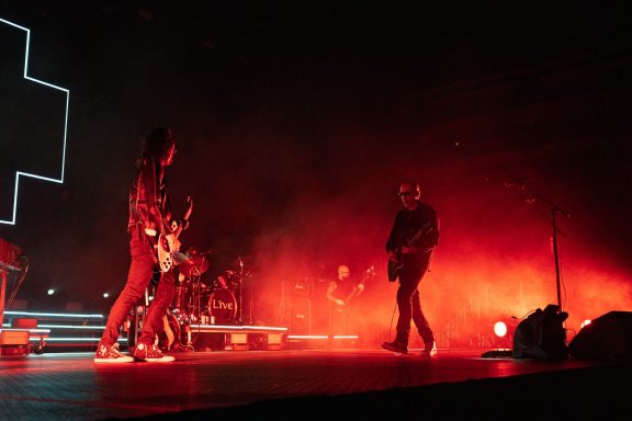 +LIVE+ - Centre Videotron Band performing on stage with dramatic red lighting and silhouettes of musicians.