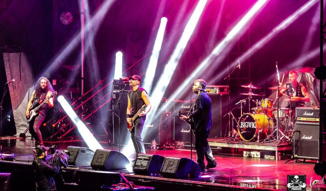 A rock band performing on stage with vibrant lighting and instruments.