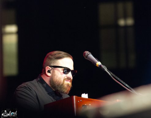 The Interrupters - l'Agora du Port de Québec Musician wearing sunglasses, focused on playing a keyboard on stage.