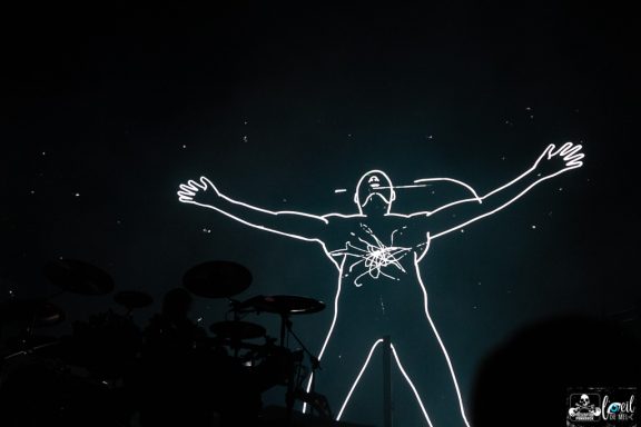 Silhouette of a figure with arms outstretched against a dark background with stars.