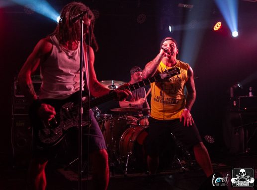 Band performing on stage with vibrant lighting and energetic poses.