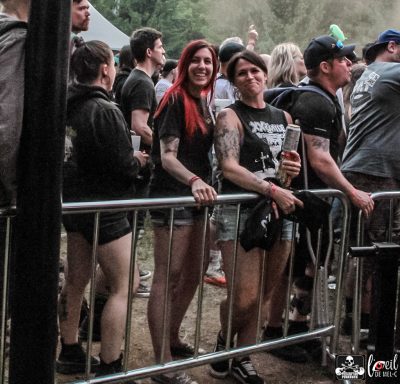 A group of festivalgoers stands by a barricade, enjoying the performance.