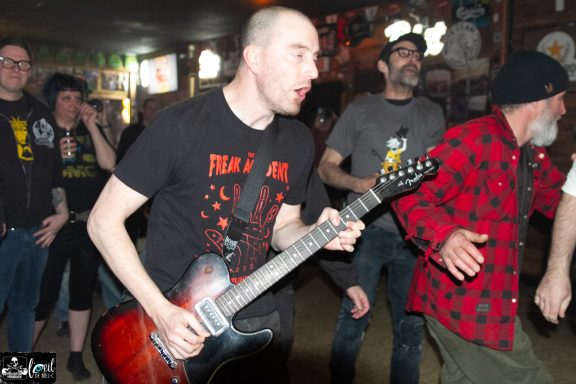 Dead Bob - La Source de la Martinière A guitarist performs energetically while fans dance nearby in a lively venue.