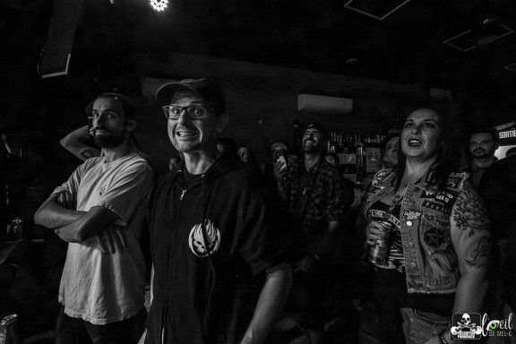 A group of people enjoying a live performance, some smiling and engaged.