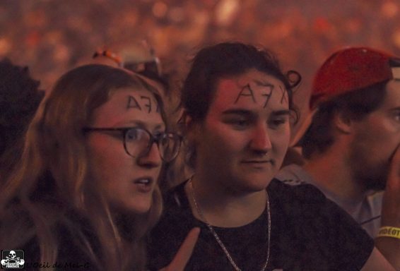 Two fans at a concert with "A7" written on their foreheads, looking excited.