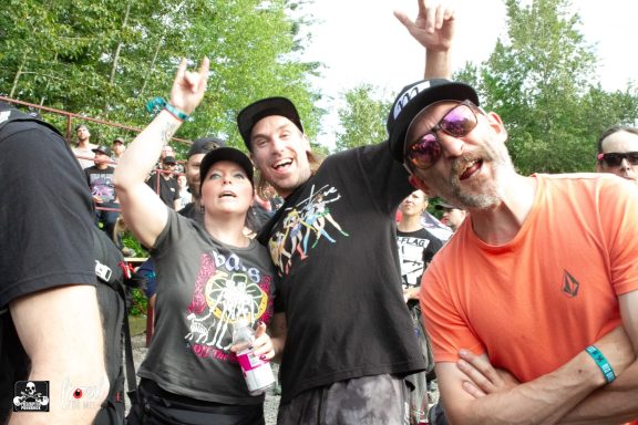 A group of friends celebrating at an outdoor event, smiling and posing for the camera.