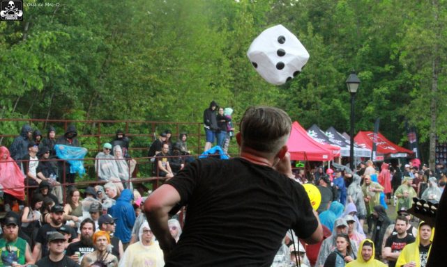 A person throws a large die into a crowd during an outdoor event.