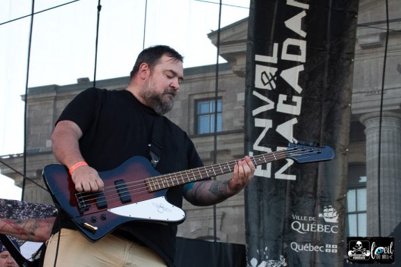 Man playing guitar on stage during a live music performance.
