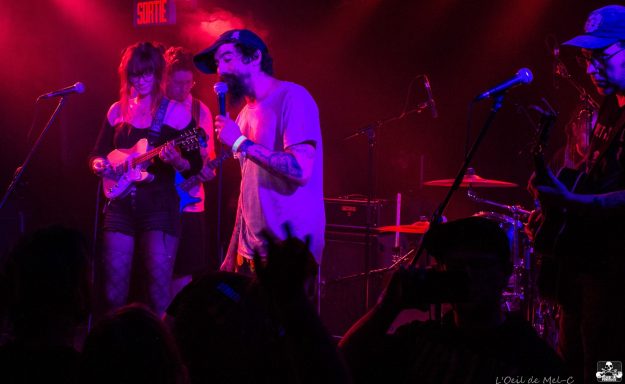 A live music performance with musicians on stage and an engaged audience.