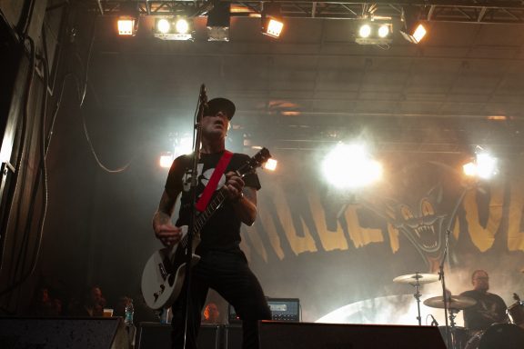 Millencolin - Red Bridge Fest 2026 Musician performing on stage with a guitar, spotlighted against a band backdrop.