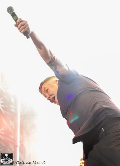 A singer passionately performing with a microphone, reaching out to the audience.