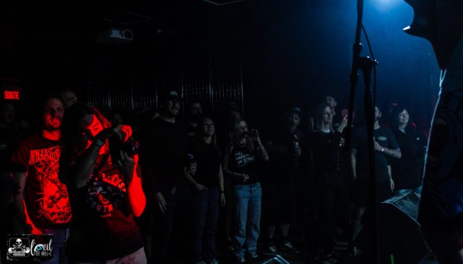Straightline - L'Anti-Bar & Spectacles Crowd enjoying a live music performance in dim lighting with blue and red highlights.
