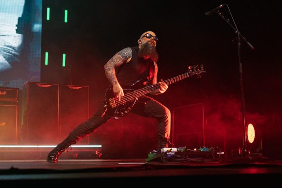 +LIVE+ - Centre Videotron A musician with a beard passionately playing electric bass on stage.