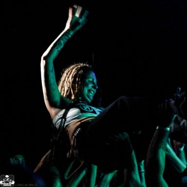 A crowd surfing performer joyfully engages with the audience during a concert.