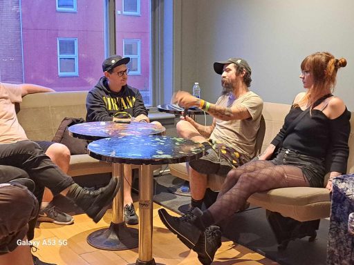 A group of people seated in a casual setting, engaged in conversation.