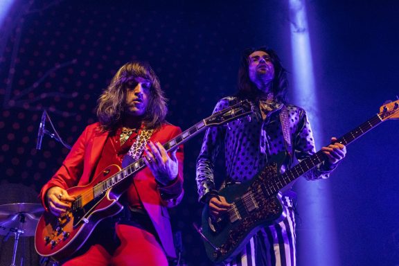 The Damn Truth - Centre Videotron Two musicians performing on stage, one in a red suit with a guitar and the other in a patterned outfit.