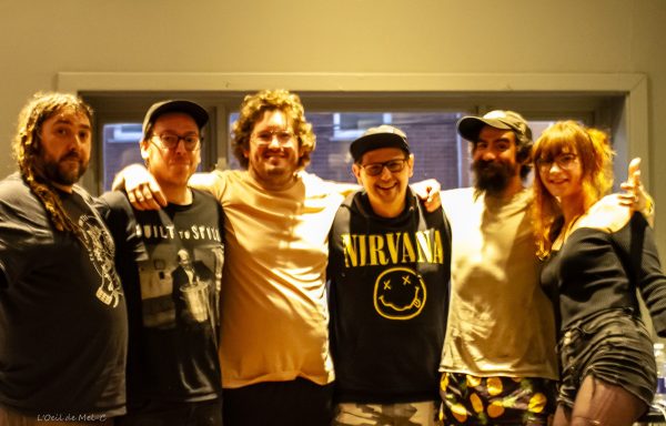 Six people standing together, wearing casual clothing, smiling at the camera.