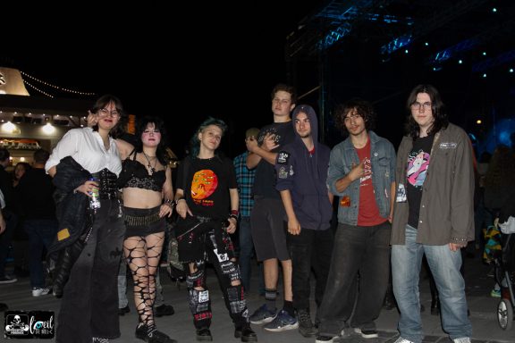 A group of diverse young people posing together at a nighttime event.