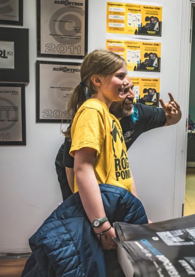 Rouge Pompier - Radiothon CKRL 89,1 Child in a yellow shirt smiles, standing next to an adult making a peace sign.