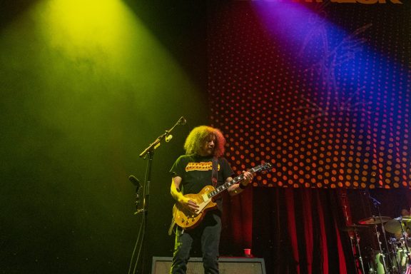 Big Wreck - Centre Videotron Musician with curly hair playing electric guitar on stage under colorful lights.