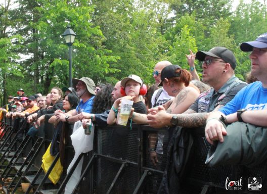 A crowd of fans at a concert, holding drinks and enjoying the performance.