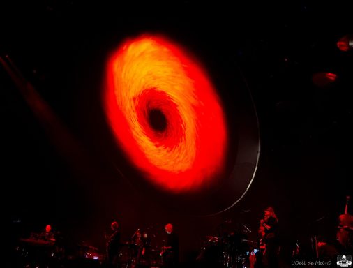 A large red circular light with a black center, set against a dark background.