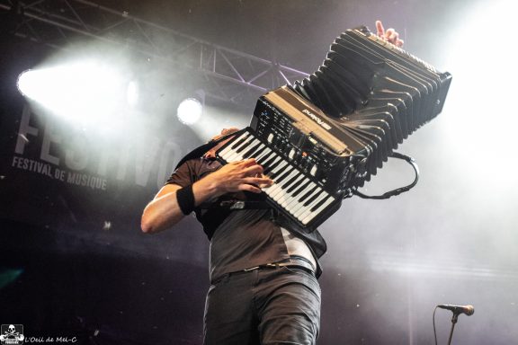 Musician passionately playing an accordion during a live performance.