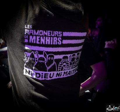 A black shirt featuring white graphics and text: "Les Ramoneurs de Menhirs" and "Ni Dieu Ni Maître."
