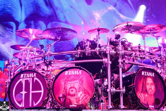 Drum kit featuring colorful artwork and prominent band logos on the drum heads.